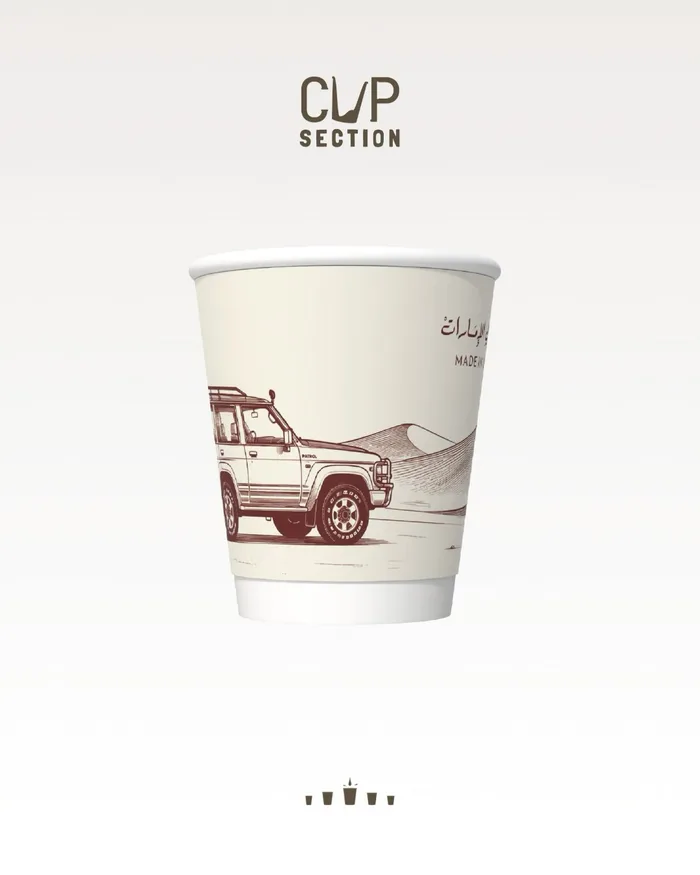Cream paper cup with a maroon sketch of a vintage 4x4 in the dunes and Made in UAE in Arabic and English.